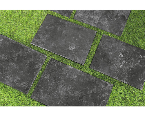 Graue Steinplatten auf einer Rasenfläche für Gartenwege