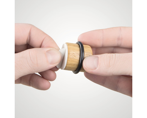 Bouchon de vin en bois avec joint en caoutchouc tenu par les mains