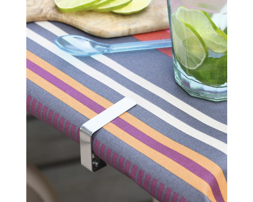 Table avec nappe, tranches de citron vert, boisson et un support de nappe en métal