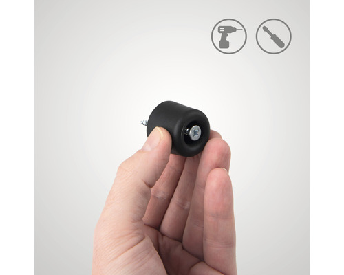 Une main tient un butoir de porte noir à monter avec une vis. Symboles d''installation en arrière-plan.