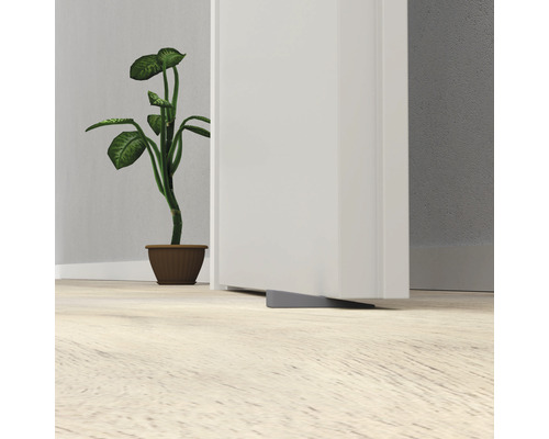 Butoir de porte gris en caoutchouc placé devant une porte.