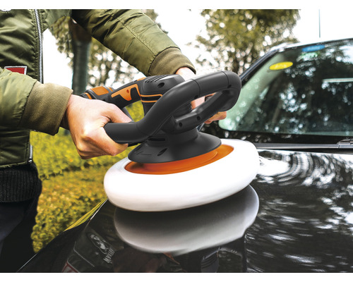 Une personne polit une voiture avec une polisseuse.