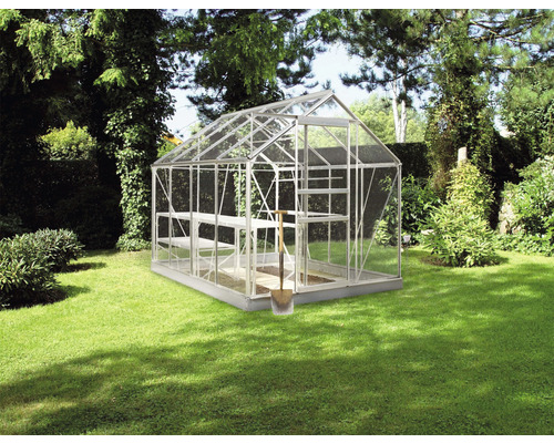 Gewächshaus aus Glas und Metall mit Regalen im Garten