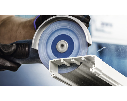 Un disque à tronçonner coupe un profilé en plastique.