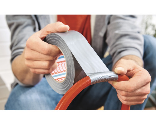 Eine Person repariert einen Schlauch mit Gewebeband.