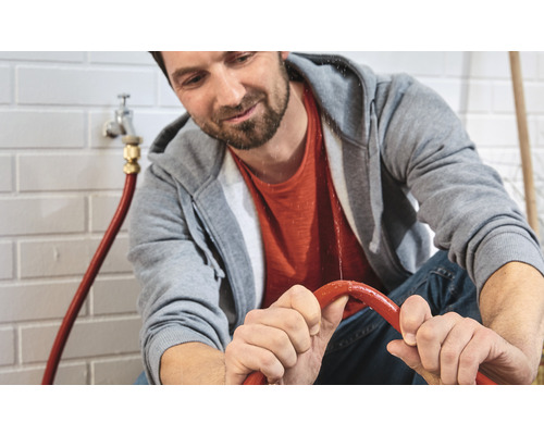 Mann repariert undichtes Wasserrohr