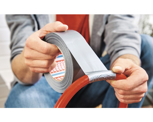 Mann repariert einen Schlauch mit Gewebeband