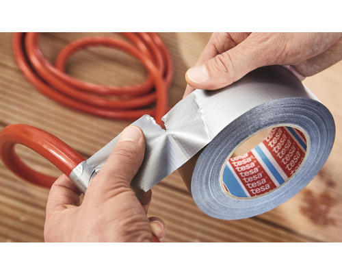 Person repariert einen Schlauch mit Gewebeband von Tesa