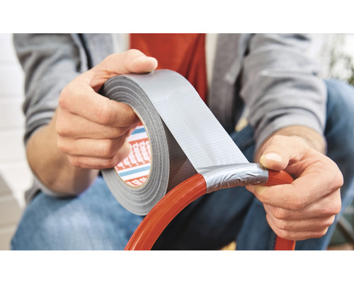 Mann repariert einen Schlauch mit Gewebeband