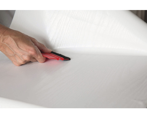 Application d''un film adhésif blanc avec une raclette