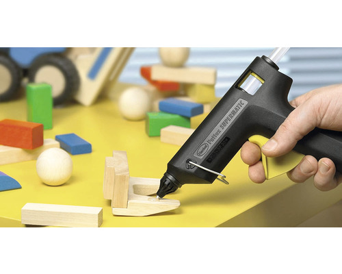 Heissklebepistole beim Verkleben von Holzbausteinen