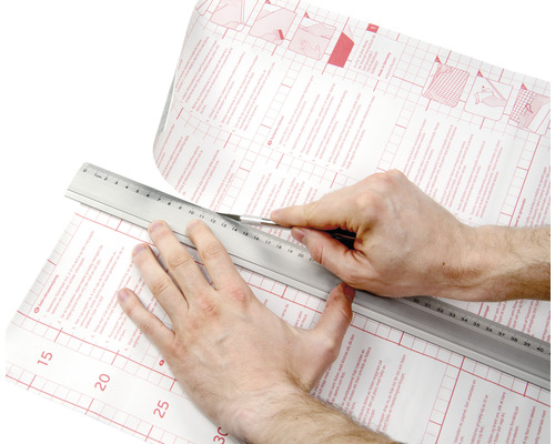 Découpe d''un film autocollant avec un couteau et une règle