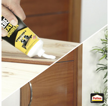 Eine Tube Montagekleber wird auf ein Holzstück aufgetragen.