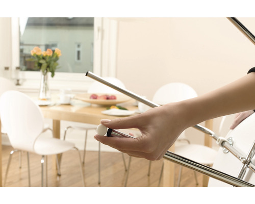 Eine Person hält einen Möbelgleiter, der an einem Stuhl angebracht wird, um Böden zu schützen.