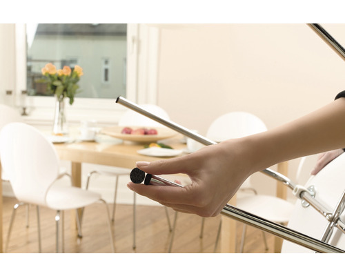 Femme fixe un patin en feutre sur un pied de chaise