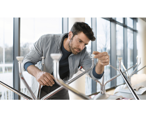 Ein Mann montiert einen Kleiderständer aus Metall.