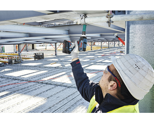 Un ouvrier du bâtiment utilise une clé à chocs sans fil sur un chantier.