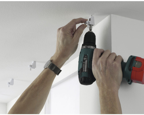 Montage d''un rail de rideau au plafond avec un tournevis sans fil.