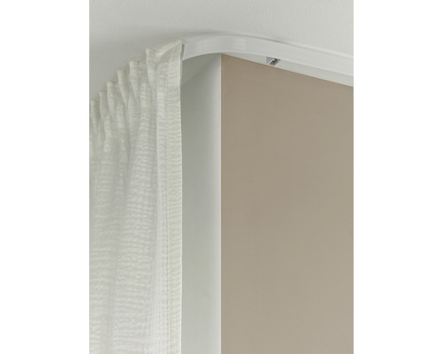 Rail de rideau courbé avec rideau monté au plafond.