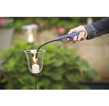 Une personne allume une bougie dans un verre avec un briquet à allumage long.