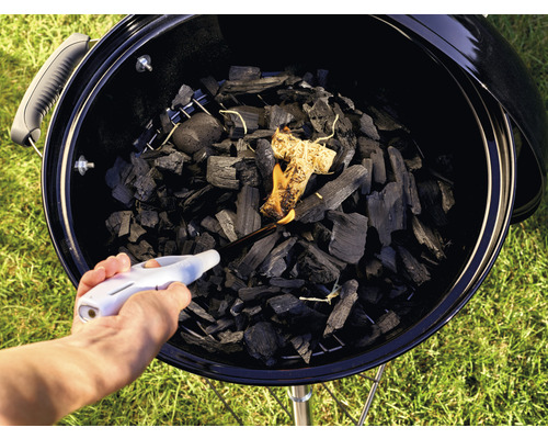 Allumage de charbon de bois dans un barbecue avec un briquet