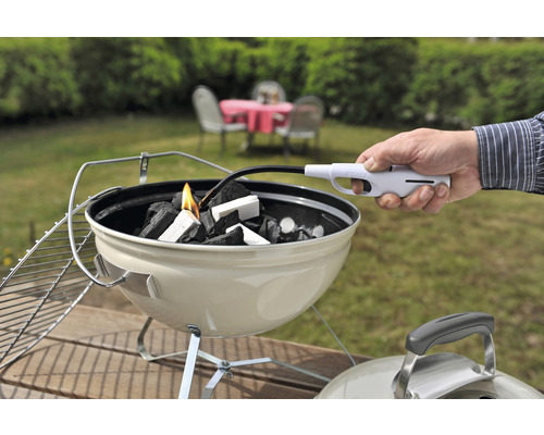 Anzünden von Grillkohle mit einem Stabfeuerzeug in einem Holzkohlegrill
