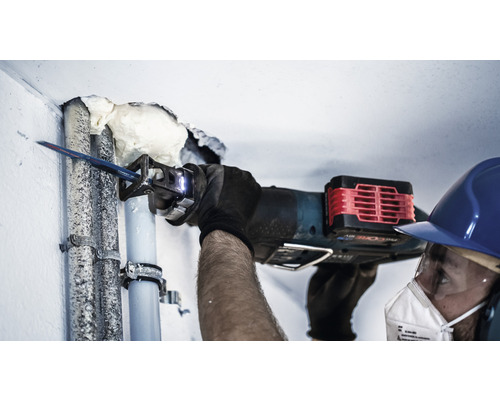 Handwerker sägt Rohr mit einer Säbelsäge