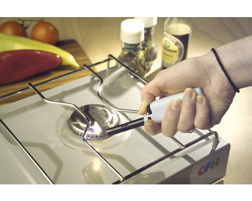 Une plaque de cuisson est allumée avec un allume-gaz.