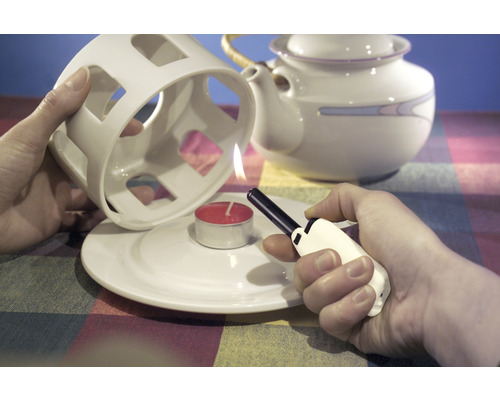 Allumage d''une bougie chauffe-plat sous un chauffe-thé avec un briquet.