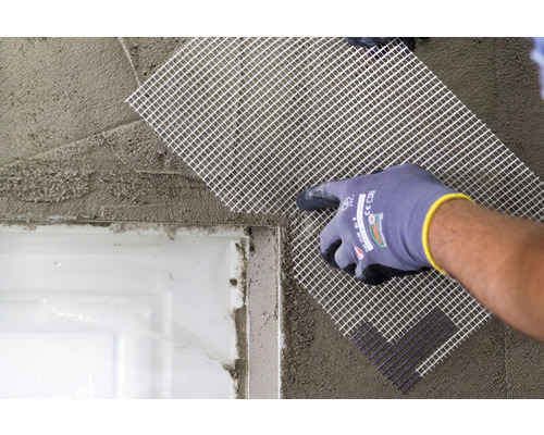 Mise en œuvre d''un tissu d''armature sur un mur enduit.