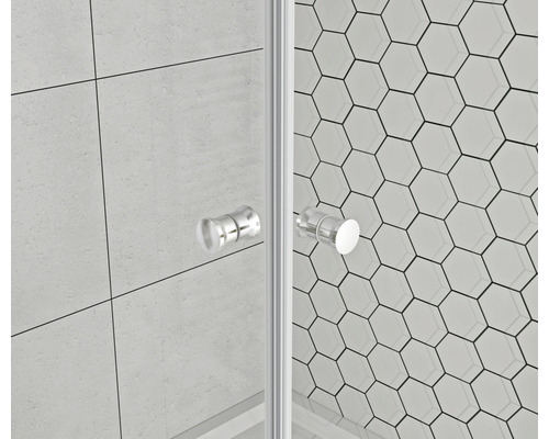 Detailaufnahme einer Duschkabine mit Glaswänden und Griffen vor einem Hintergrund aus sechseckigen Fliesen