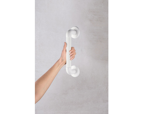 Une main tient une barre d''appui de salle de bain blanche sur un mur