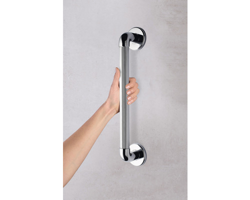 Une main tient une barre d''appui pour la salle de bains.