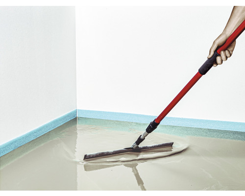 Revêtement de sol appliqué avec une raclette et un manche rouge