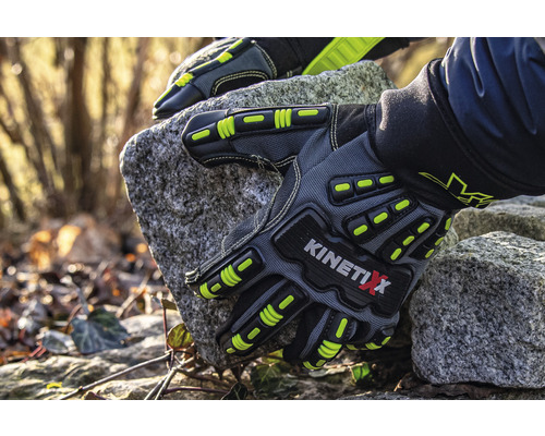 Ein Paar graue KinetiXx Arbeitshandschuhe hält einen Stein