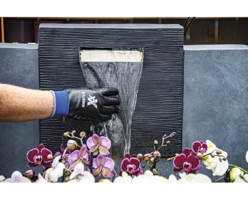 Dekorativer Zimmerbrunnen mit Wasserfall und Orchideen