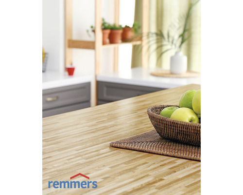 Scène de cuisine avec plan de travail en bois, corbeille de fruits et logo Remmers