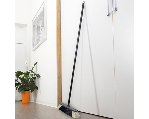 Balai avec manche, appuyé contre une porte