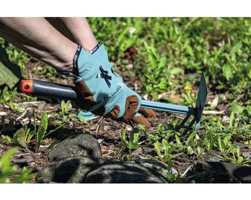 Gartenarbeit mit einer Unkrauthacke und Gartenhandschuhen.