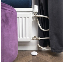 Thermostat de radiateur avec radiateur et capteur de température sur plancher en bois