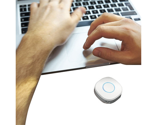 Eine Person tippt auf einer Laptoptastatur mit einem zusätzlichen Steuergerät in der Nähe.