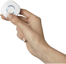 Une main tient un interrupteur sans fil rond