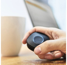 Une main tient une télécommande noire.