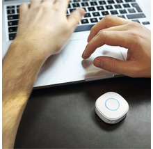 Personne travaillant sur un ordinateur portable avec un appareil Smart Home sur la table