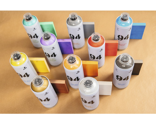 Mehrere Farbspraydosen der Marke Montana 94 mit farbigen Holzstücken