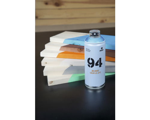 Eine Dose Montana 94 Sprühfarbe neben bemalten Holzbrettern