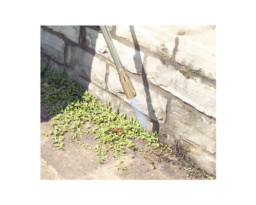 Unkrautbekämpfung an einer Steinmauer mit einem Unkrautvernichter