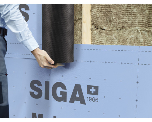 Personne installant un frein-vapeur SIGA sur un mur avec ossature en bois et isolation