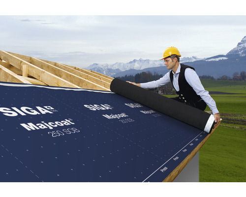 Un artisan pose un rouleau de sous-toiture SIGA Majcoat 250 SOB sur un toit