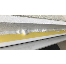 Vue détaillée d''un joint de fenêtre avec bande d''étanchéité et mastic.